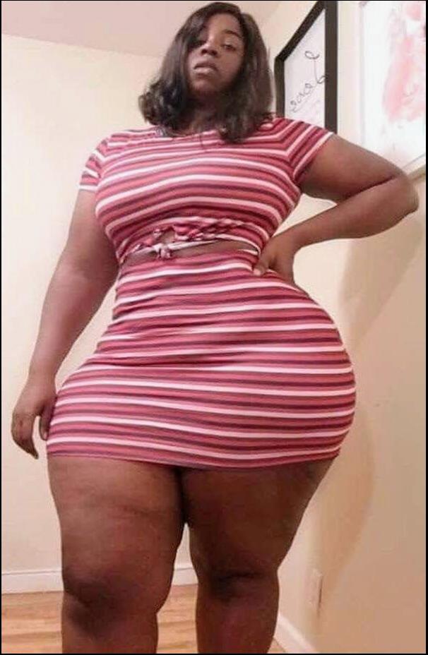 a woman in a pink dress is standing on a wall