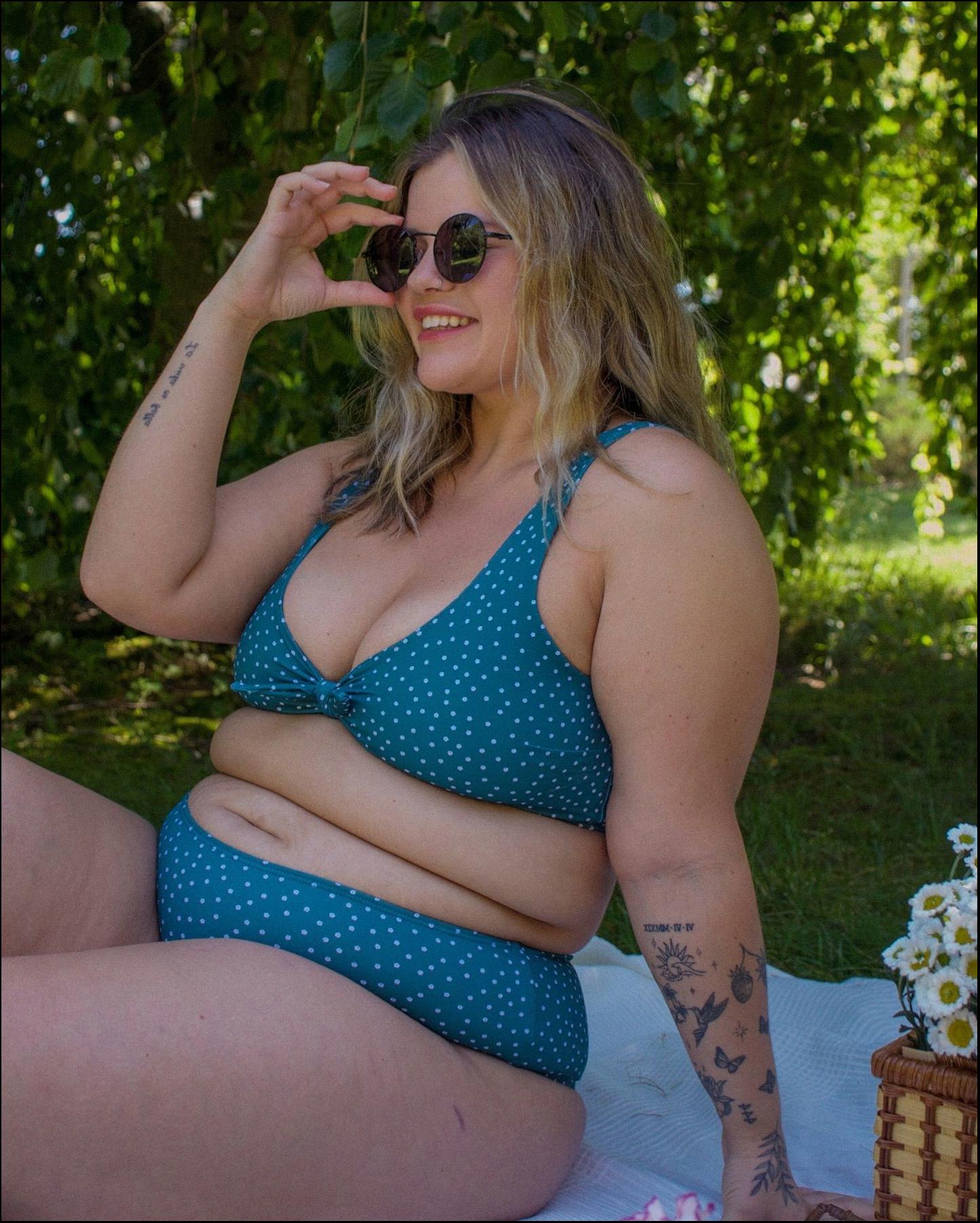 a woman is sitting on a beach with a cell phone