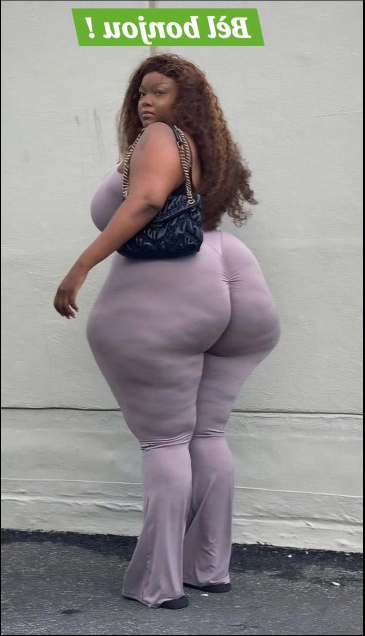 a woman is standing on the sidewalk with a pink umbrella