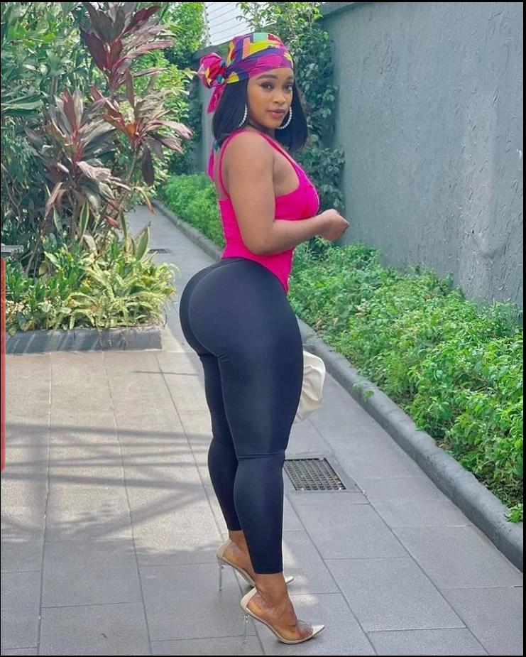 a woman in a pink dress is on a sidewalk