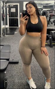 a woman is standing in a room with a cell phone