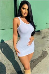 a woman in a pink dress standing on a sidewalk