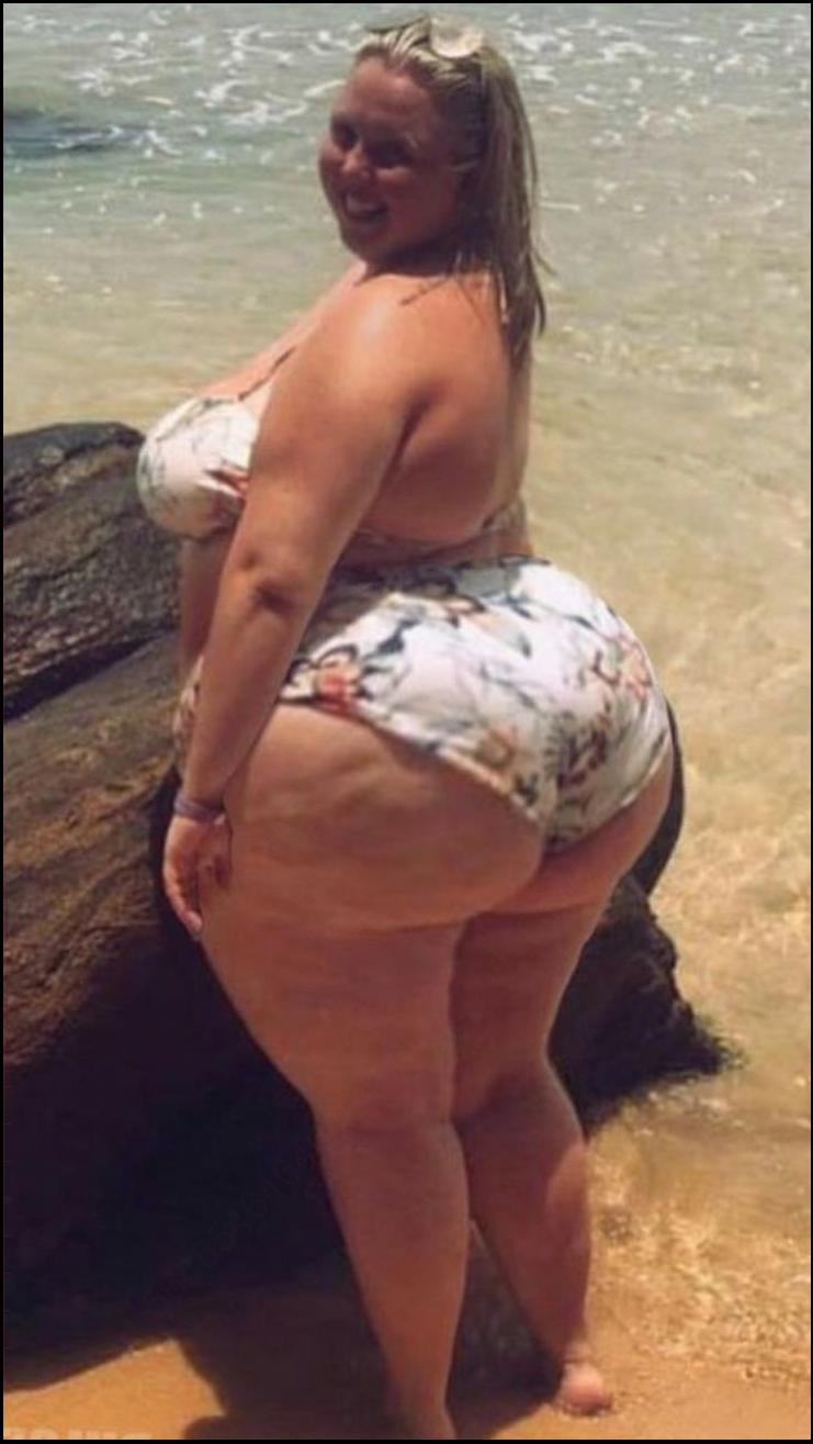 a woman is standing on a beach with a surfboard