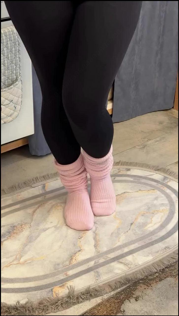 a woman is standing on a sidewalk with a shoe