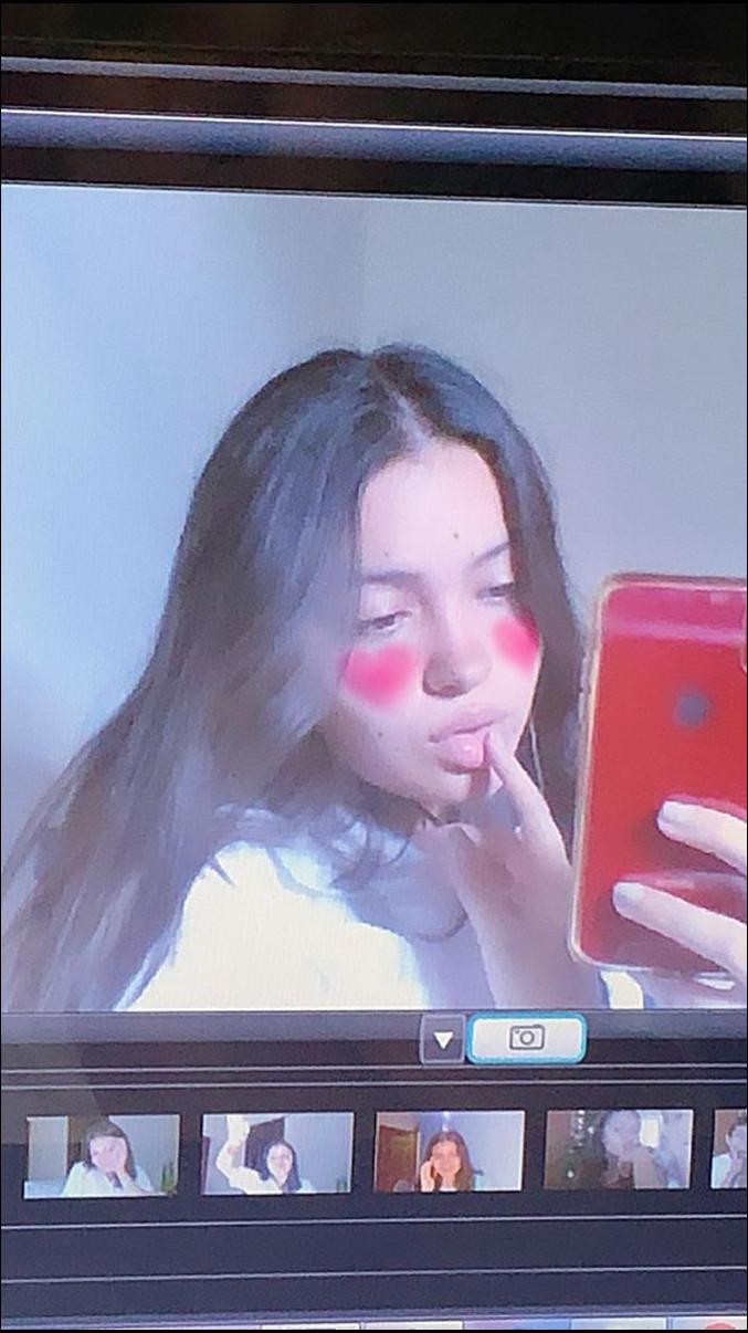 a woman is holding a tv remote in front of a picture