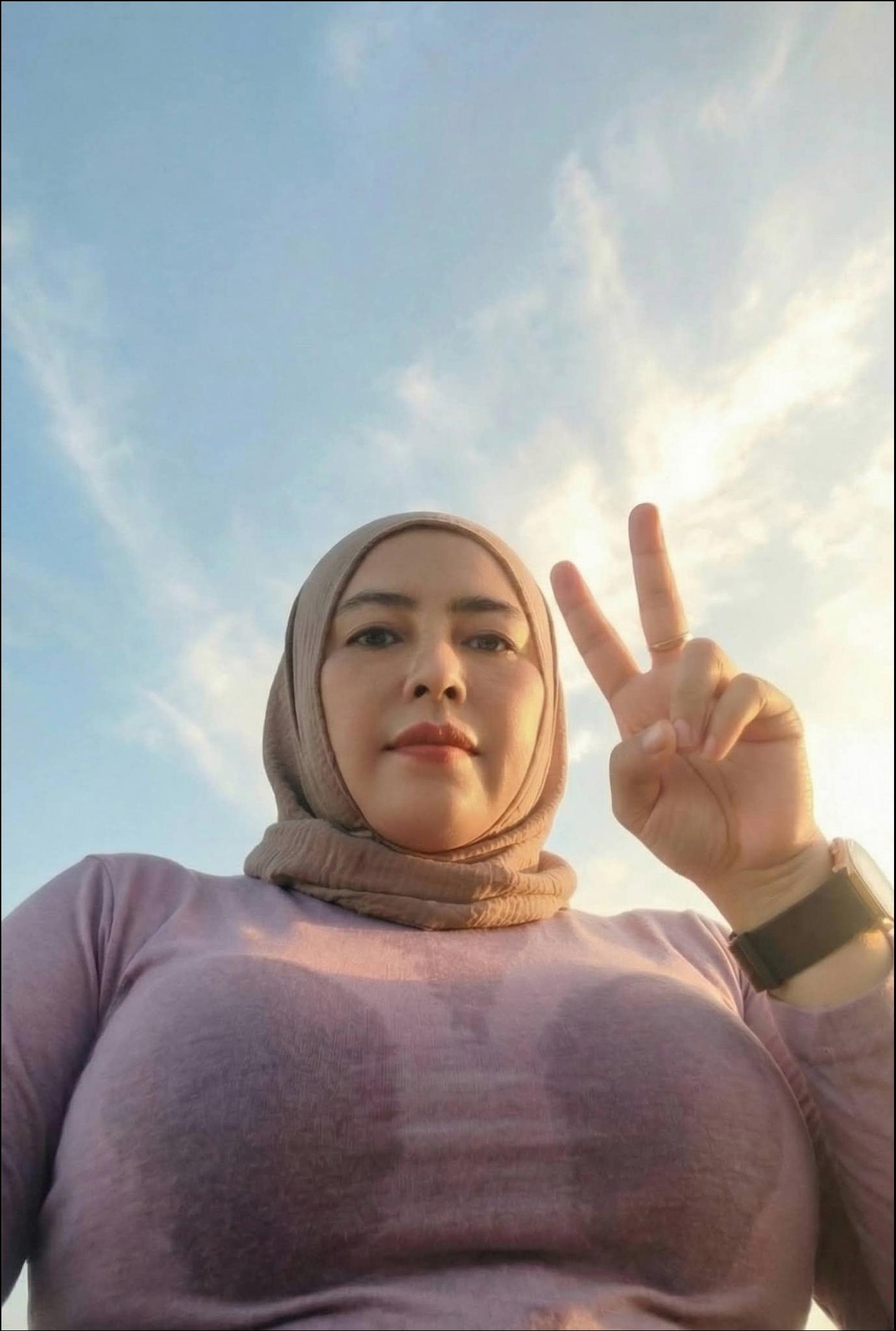 a woman is standing in the sun with a white umbrella