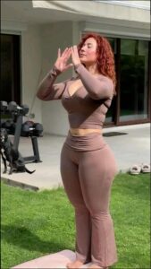 a woman dressed in a black dress and holding a pink object