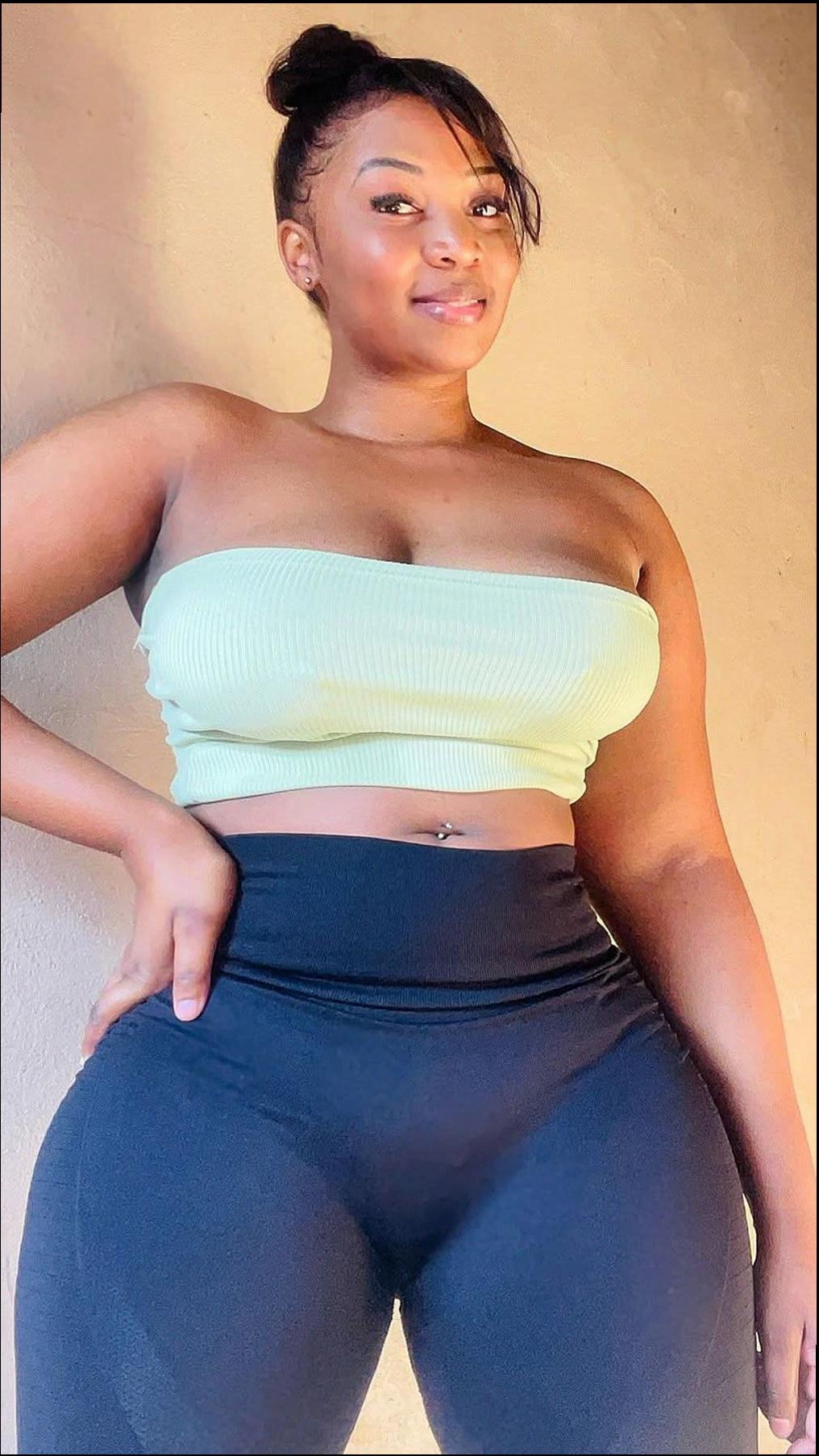 a woman is sitting on a white bed with a blue shirt