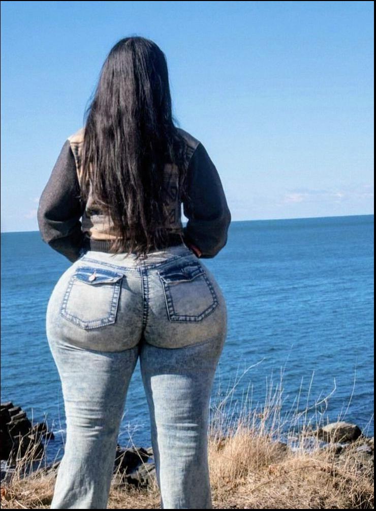 a woman standing on a beach with a surfboard