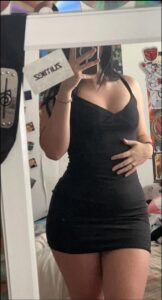 a woman in a white dress standing in front of a refrigerator