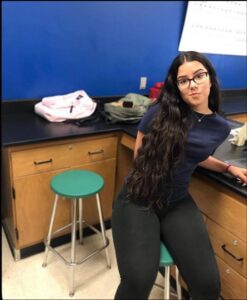 a woman is sitting on a counter in a kitchen