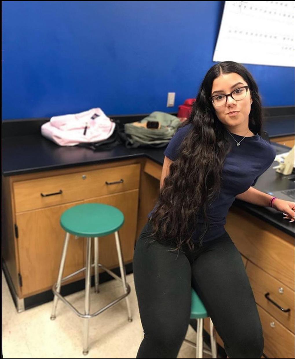 a woman is sitting on a counter in a kitchen
