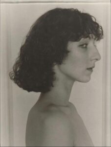 a woman is standing in a mirror with a white towel