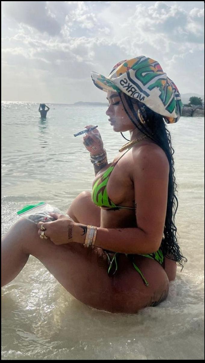 a woman is sitting on a beach with a cell phone