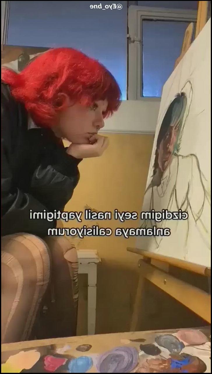 a woman is painting a painting on a wall