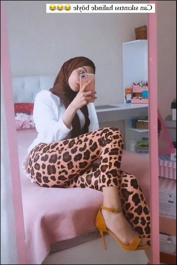 a woman sitting on a bed with a phone