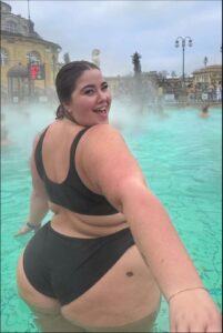 a woman is standing in the water with a surfboard