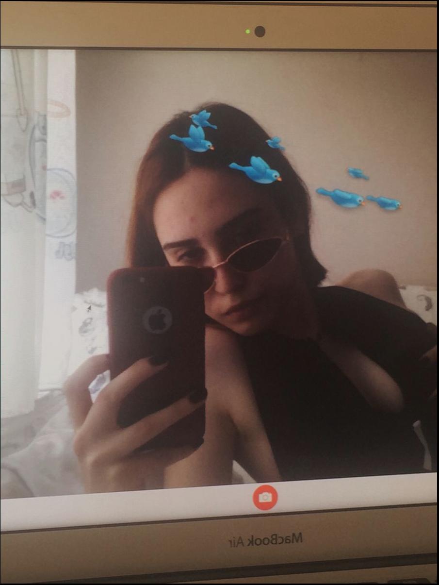 a woman is holding a cell phone in front of a picture