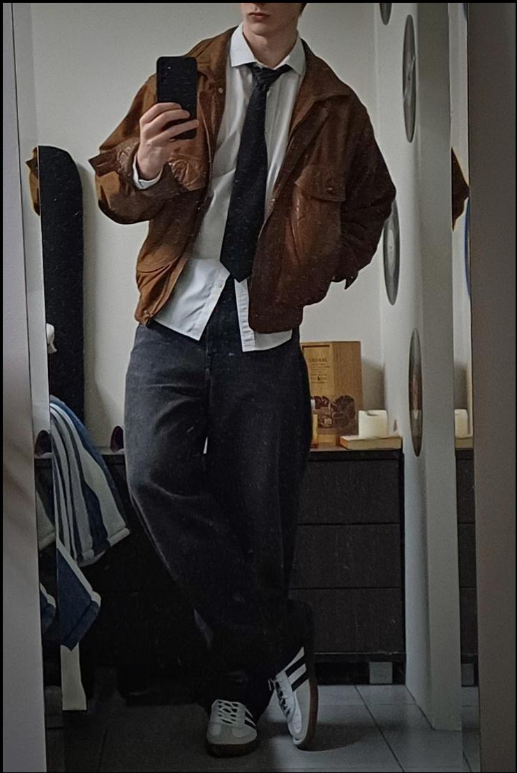 a man in a suit and tie is holding a cell phone