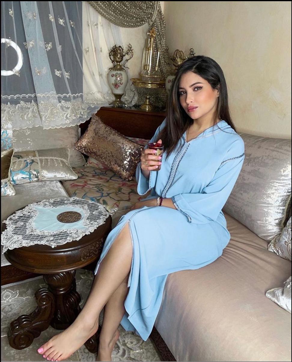 a woman is sitting on a couch with a bottle of water