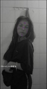 a girl with a black hair standing in front of a wall