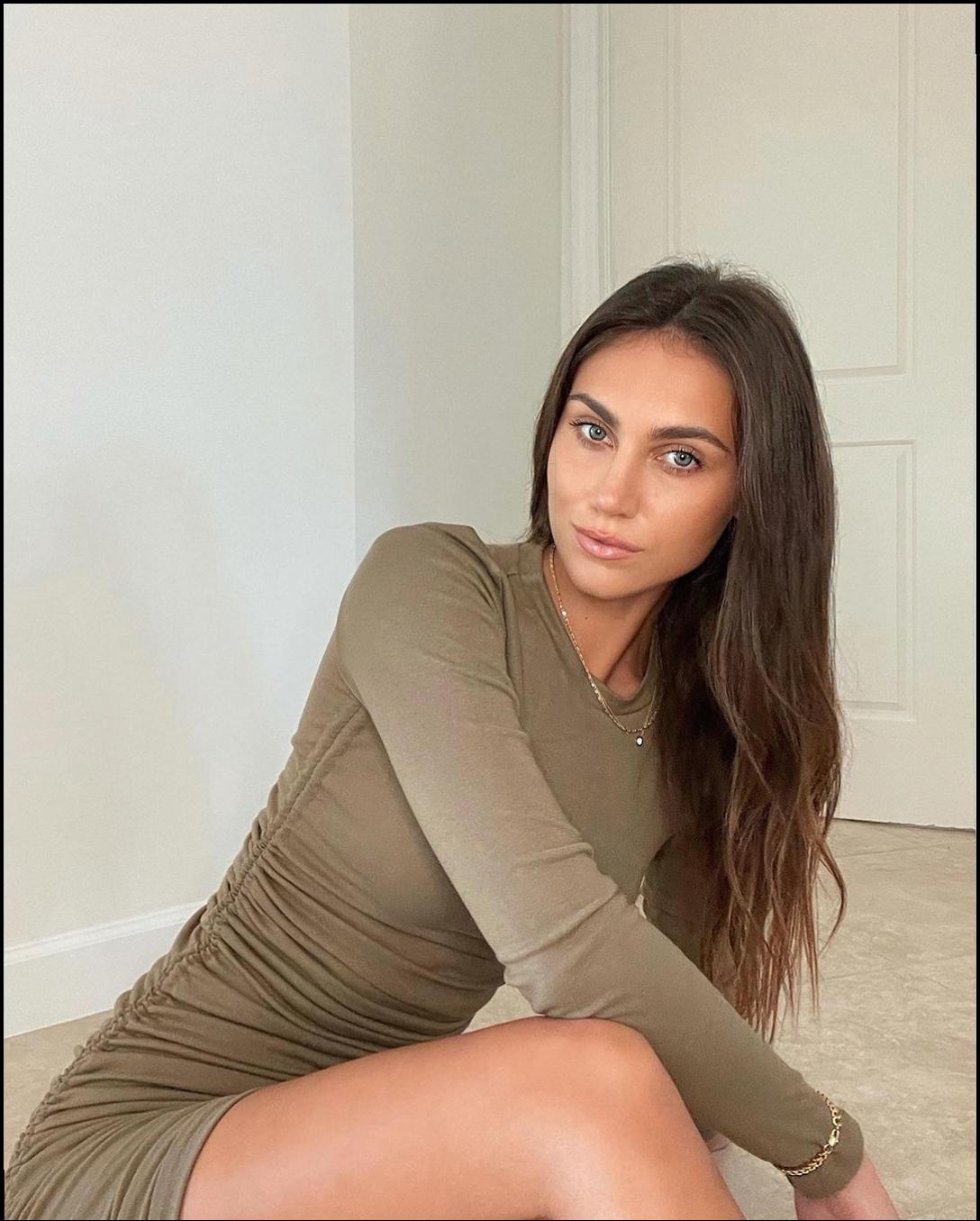 a woman is sitting on the ground with a white shirt
