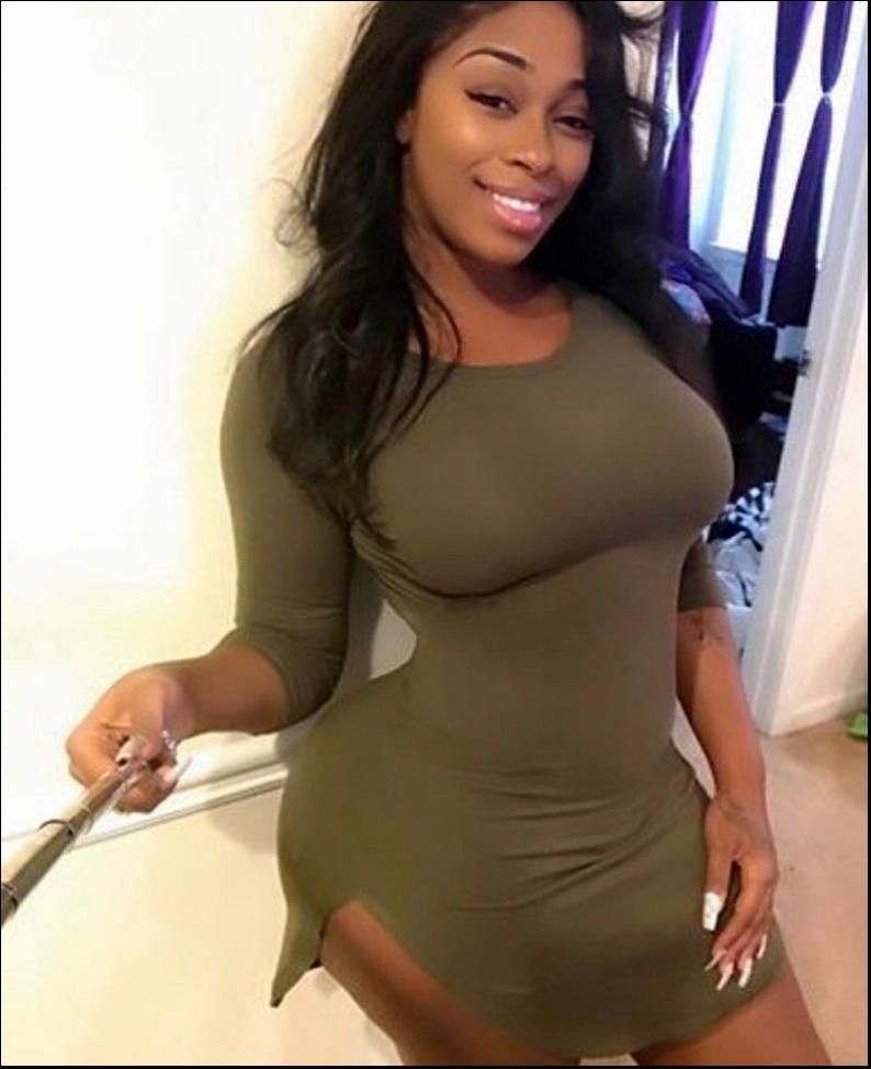 a woman in a red shirt and black shorts posing for a picture