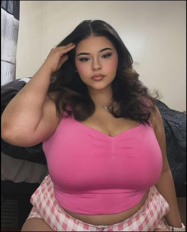 a woman is posing for a picture with a pink flower