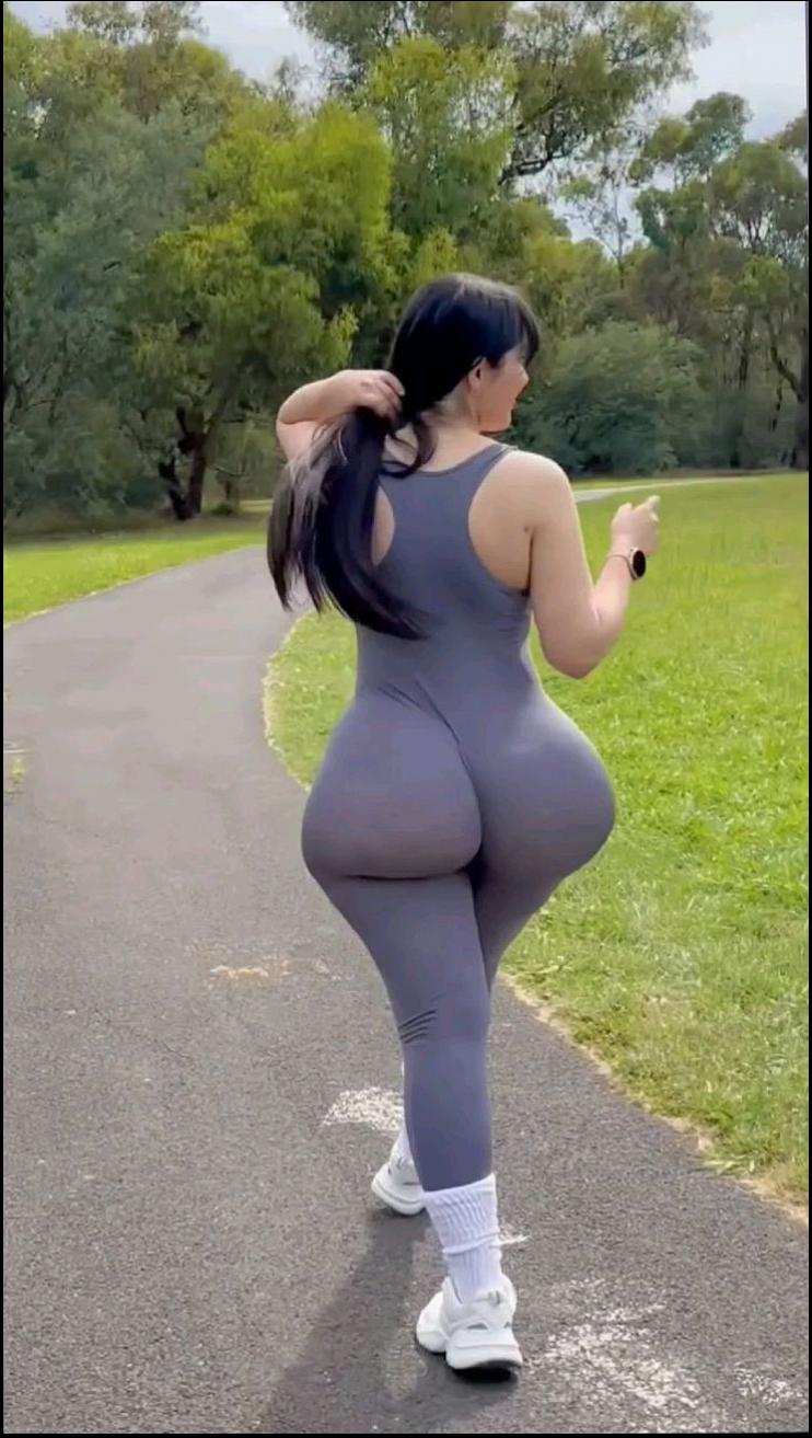 a woman in a pink dress is standing on a sidewalk