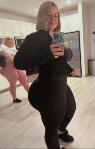 a woman in a black dress holding a cell phone