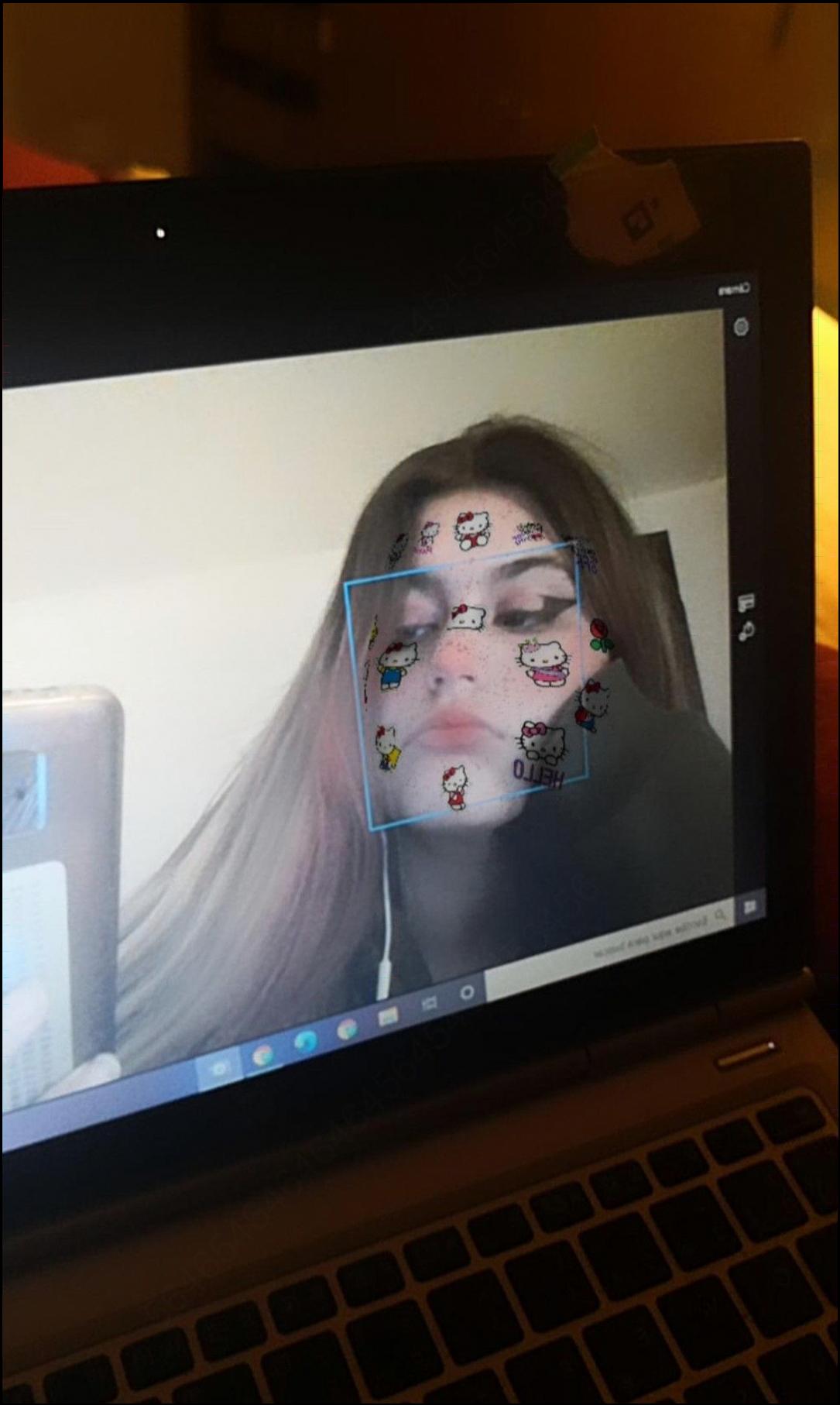 a woman is holding a laptop and a picture of a cat