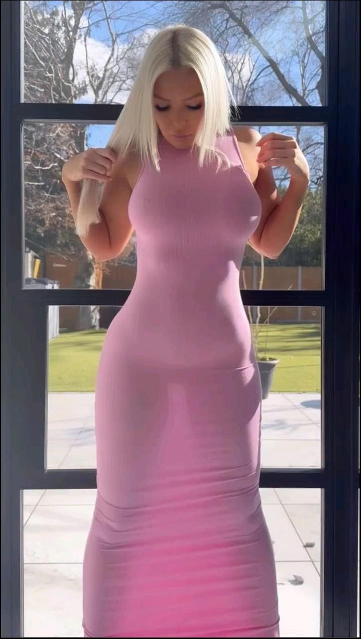 a woman in a pink dress is holding a pink flower