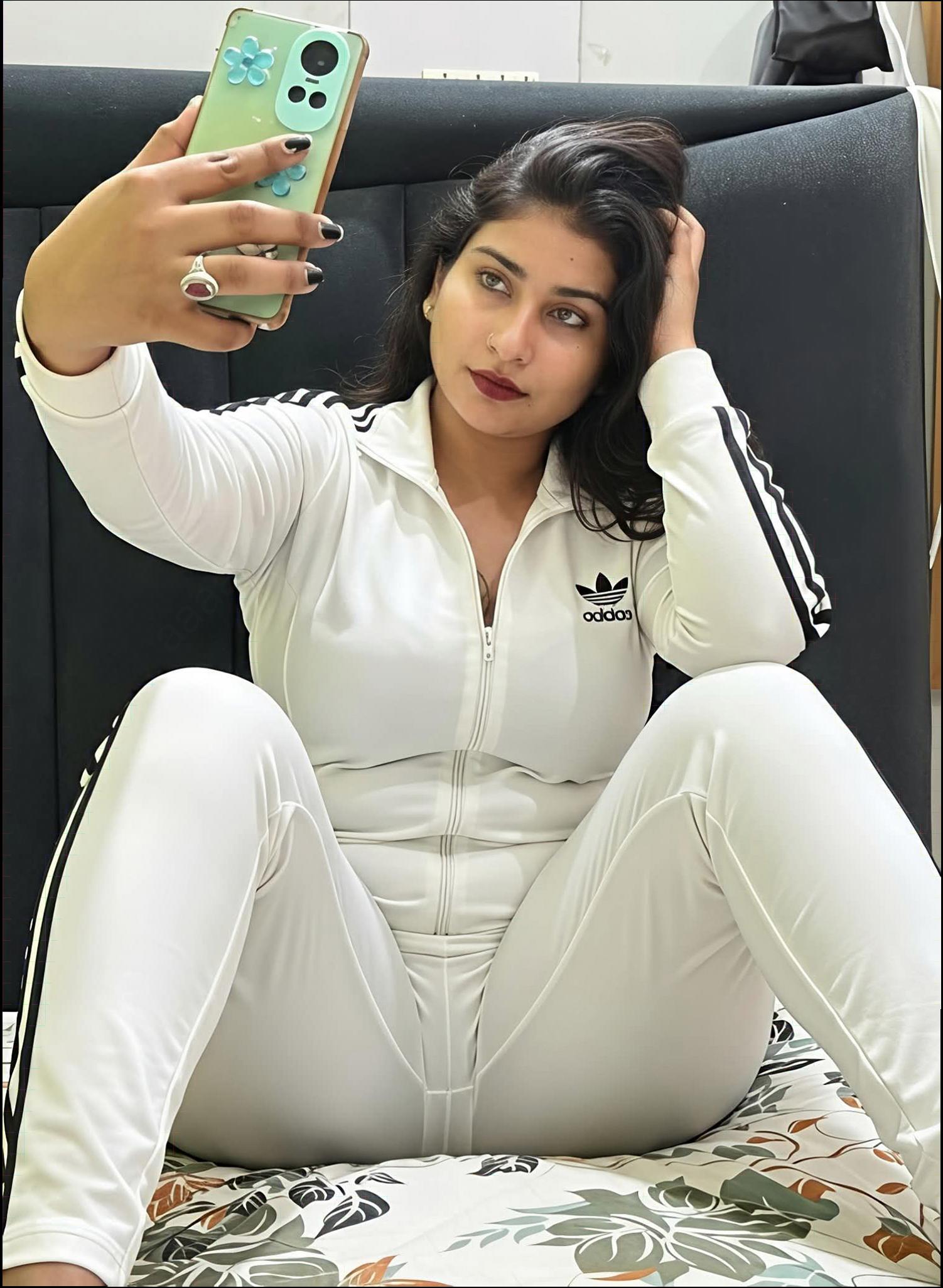 a woman is sitting on a couch holding a cell phone