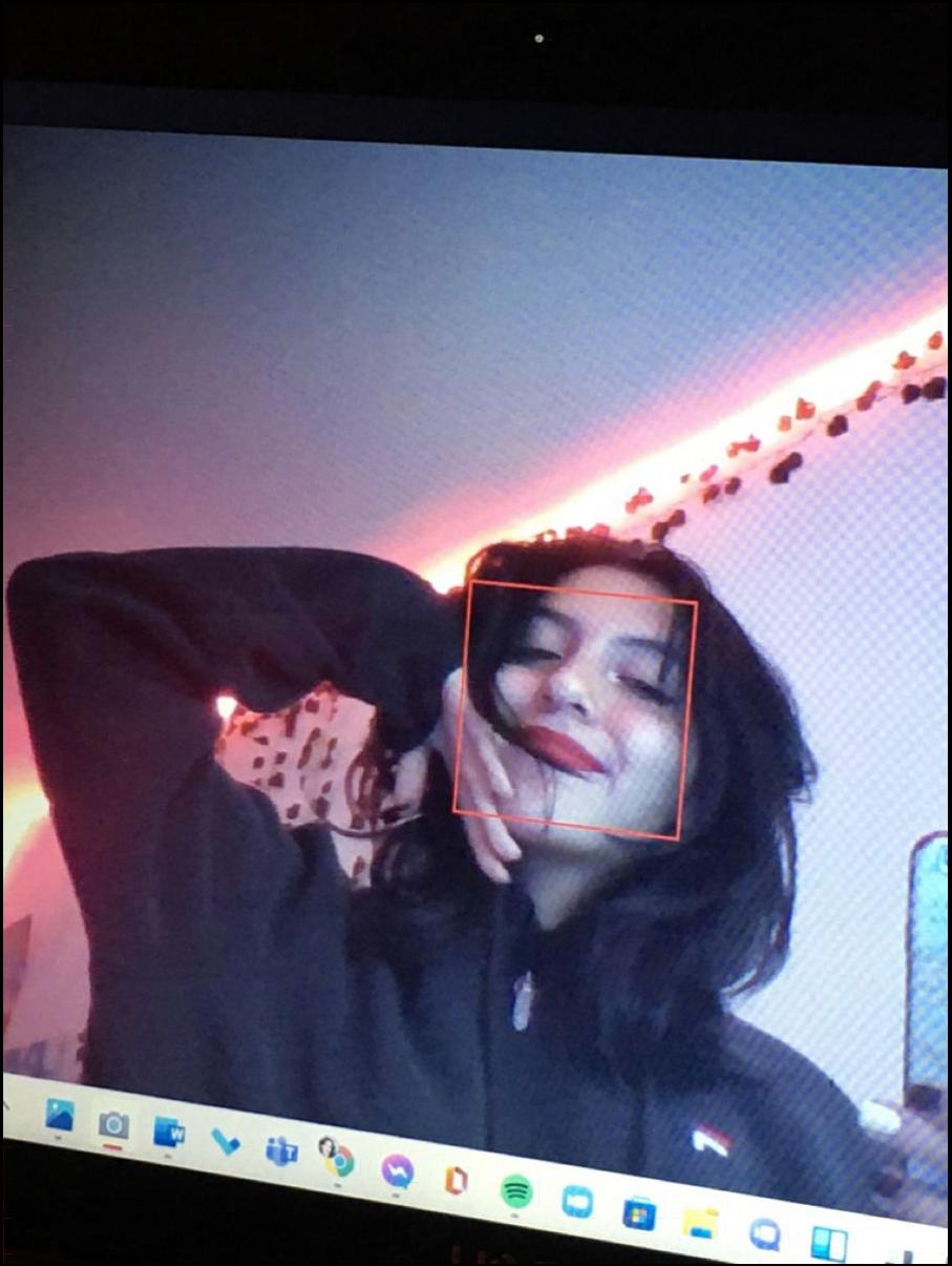 a woman is talking on a cell phone while a man is standing behind her