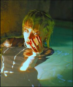 a man is drinking water out of a faucet