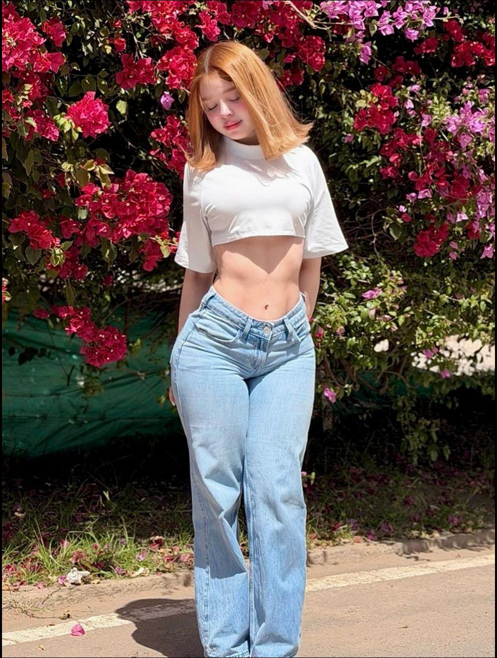 a woman is standing on a sidewalk with a pink umbrella