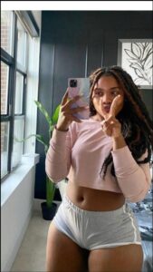 a woman holding a pink teddy bear in a bathroom