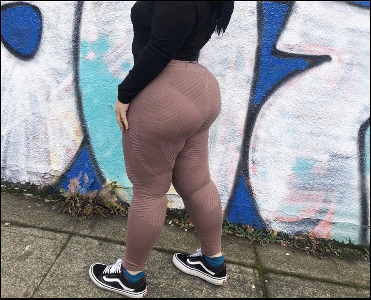 a woman is standing on a sidewalk with a skateboard