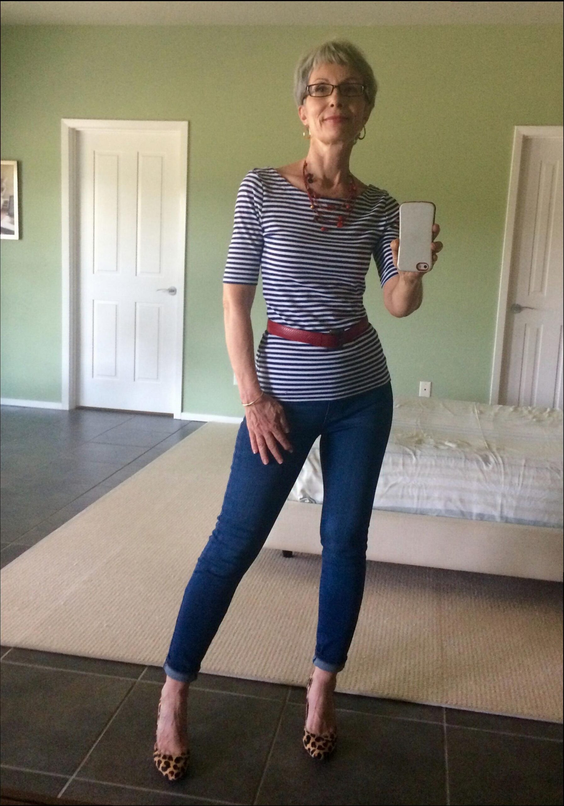 a woman standing on a sidewalk holding a white object