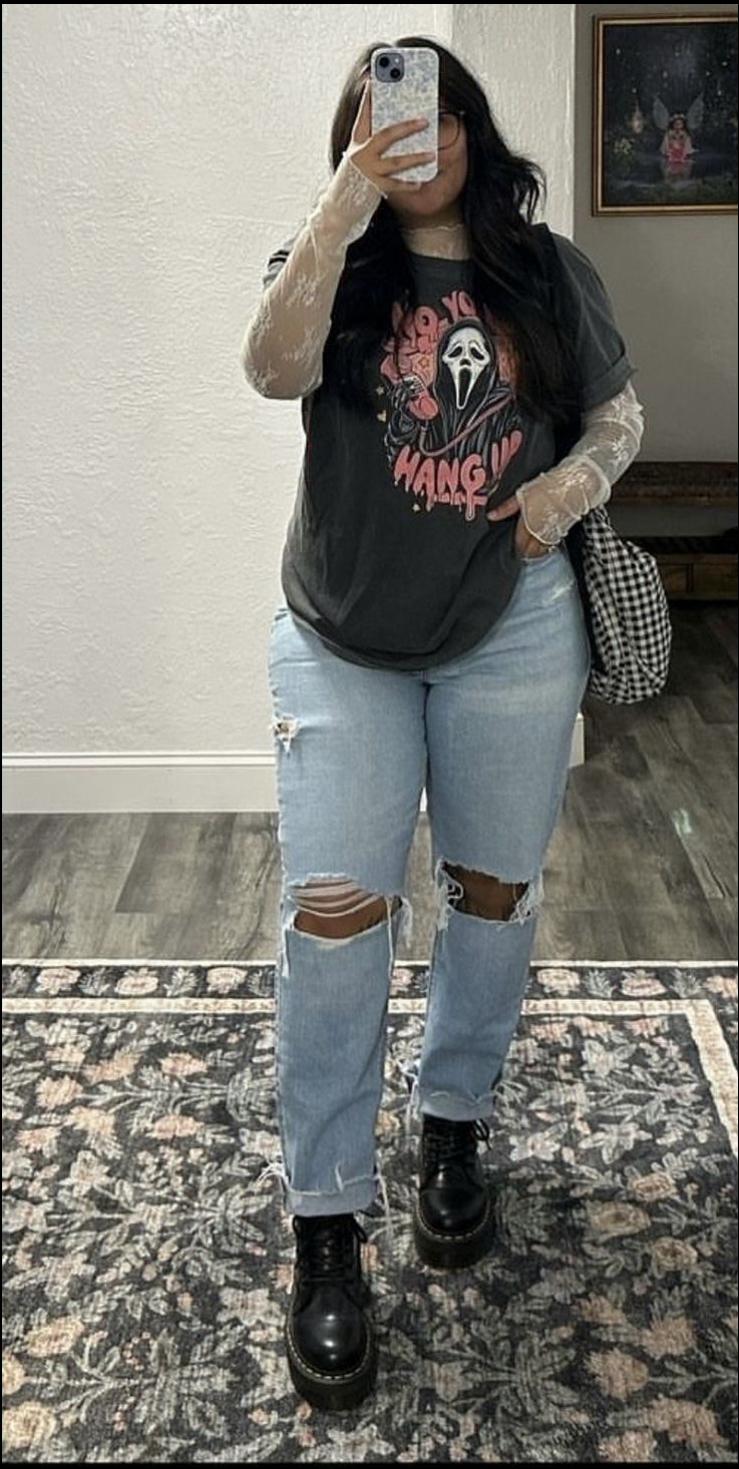 a woman is standing in a room with a cell phone