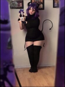 a woman in a black dress is holding a camera