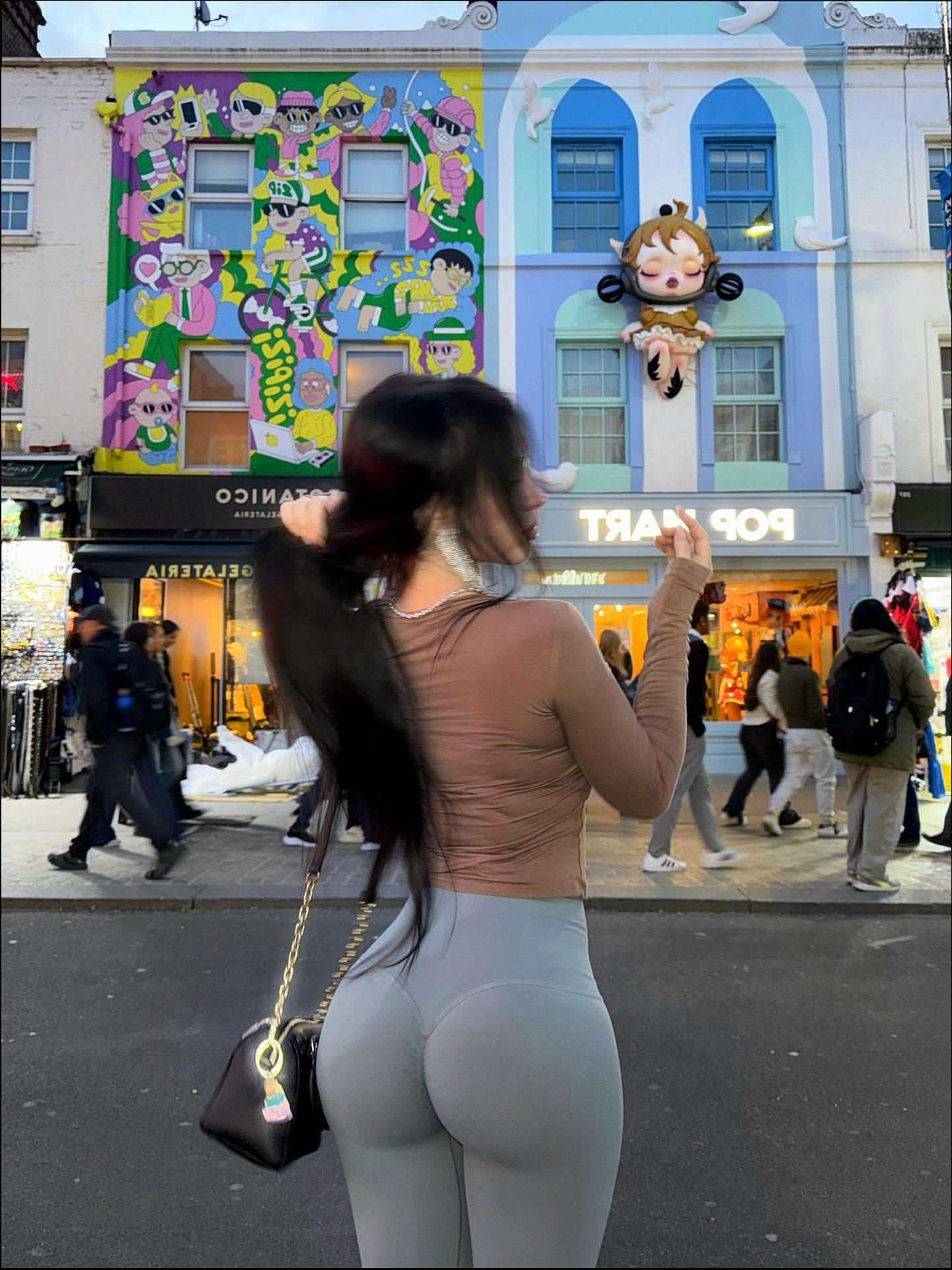 a woman in a black dress is holding a cell phone