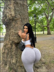 a woman is posing for a picture with a cell phone