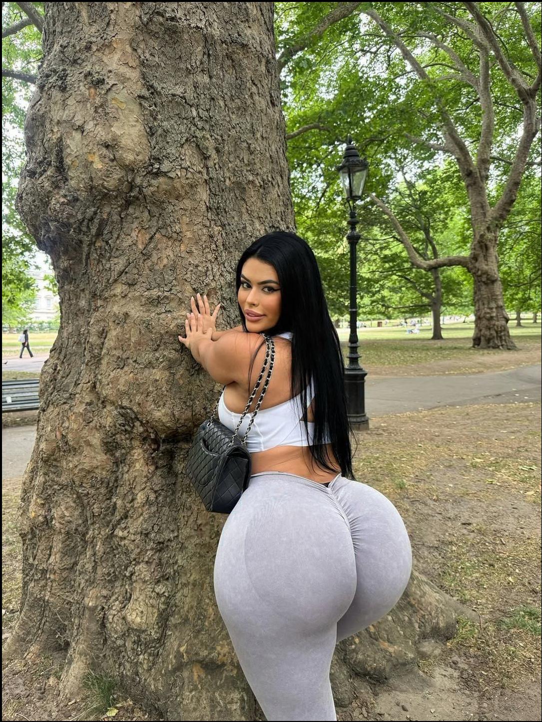 a woman is posing for a picture with a cell phone