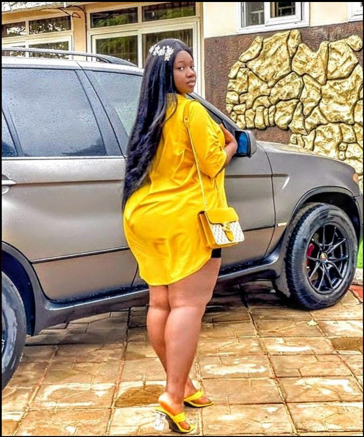 a woman in a yellow dress standing on a sidewalk