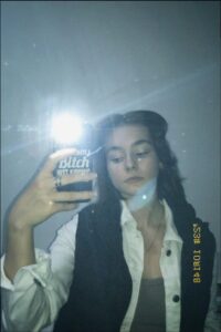 a woman holding a drink and a sign