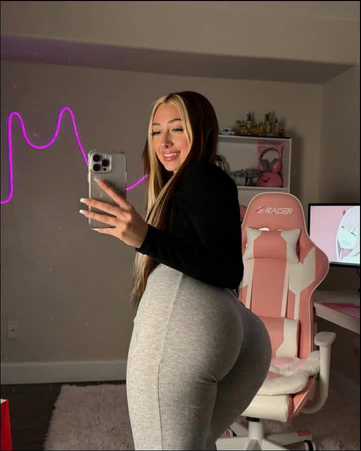 a woman is holding a cell phone in front of a wall