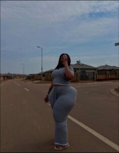 a woman is standing on a street with a cell phone