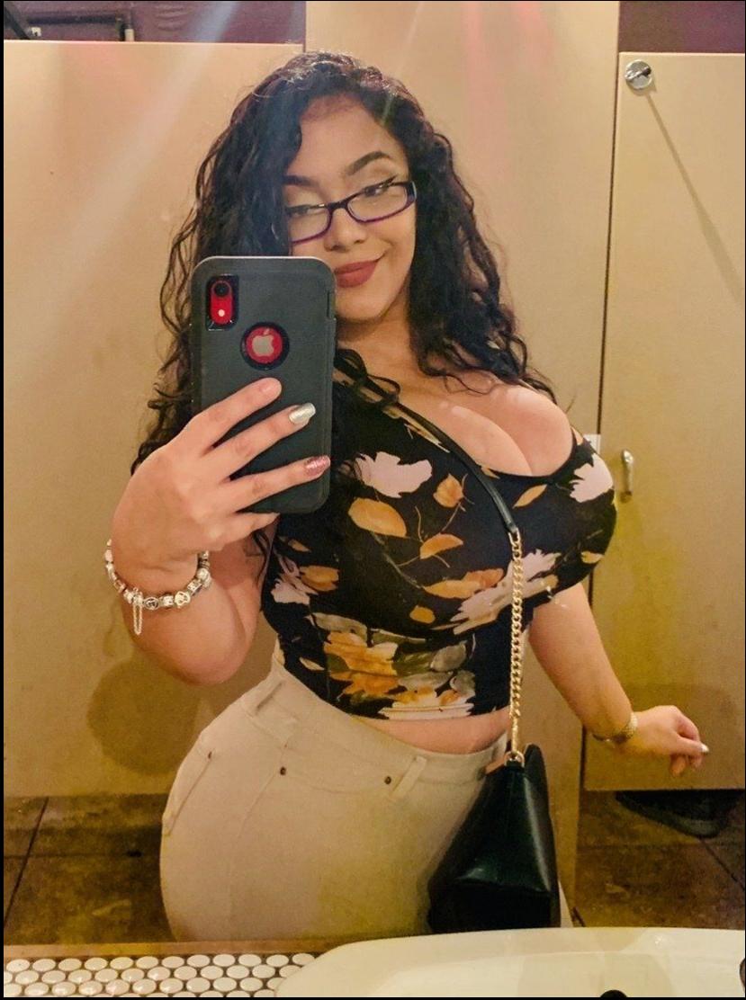 a woman is holding a cell phone in front of a mirror