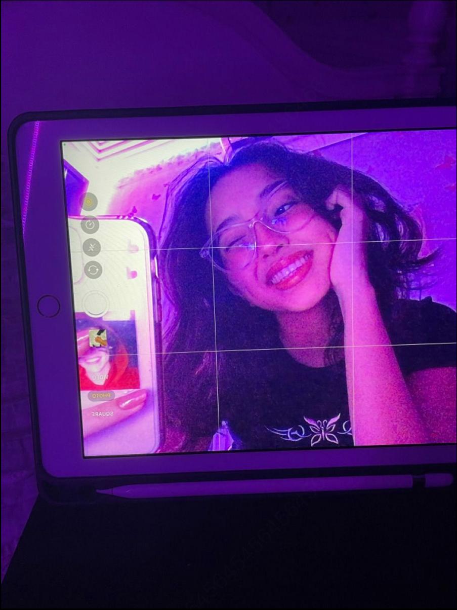 a woman is holding a cell phone in front of a tv